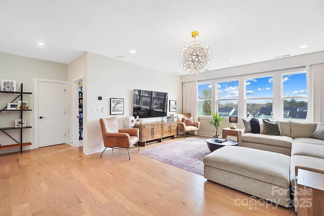 living room with light hardwood / wood-style flooring and a chandelier