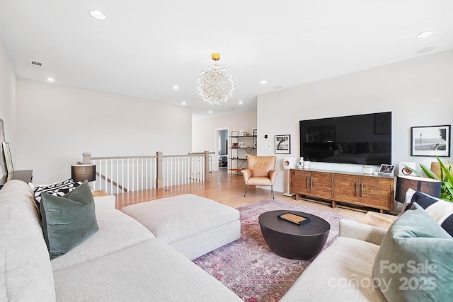 living room with light hardwood / wood-style flooring and a chandelier