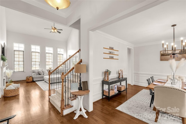 interior space featuring hardwood / wood-style flooring, ceiling fan with notable chandelier, and ornamental molding