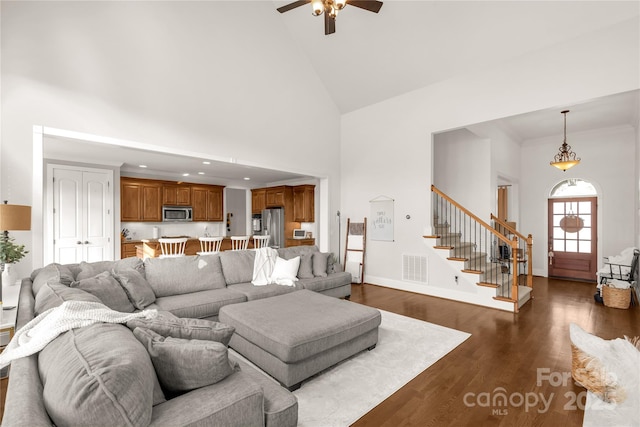 living room with crown molding, dark wood-type flooring, high vaulted ceiling, and ceiling fan