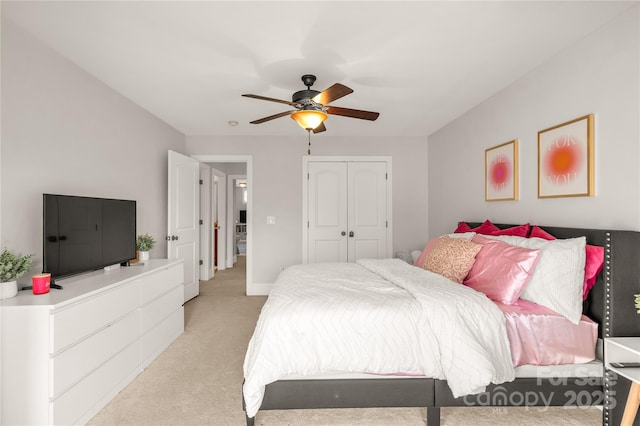 bedroom featuring light colored carpet, a closet, and ceiling fan