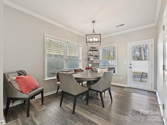 dining room with dark hardwood / wood-style flooring, ornamental molding, and a chandelier