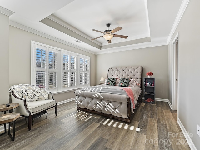 bedroom with ornamental molding, ceiling fan, dark hardwood / wood-style flooring, and a tray ceiling