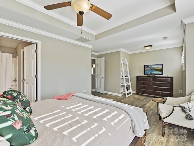 bedroom featuring a raised ceiling, ornamental molding, ceiling fan, and dark hardwood / wood-style flooring