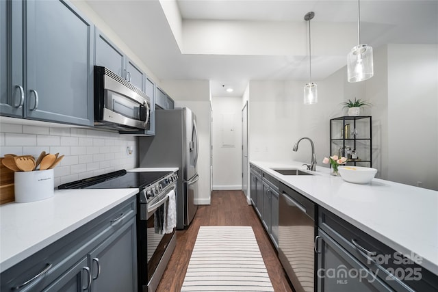 kitchen with sink, stainless steel appliances, dark hardwood / wood-style floors, decorative backsplash, and decorative light fixtures