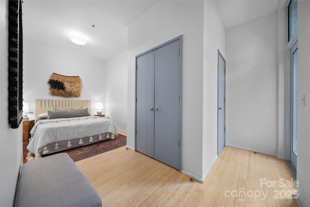 bedroom with light wood-type flooring and a closet