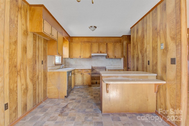 kitchen with a breakfast bar, wood walls, and kitchen peninsula