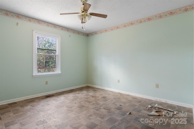 unfurnished room with ceiling fan and a textured ceiling