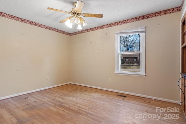 unfurnished room featuring a textured ceiling, ceiling fan, and light hardwood / wood-style flooring