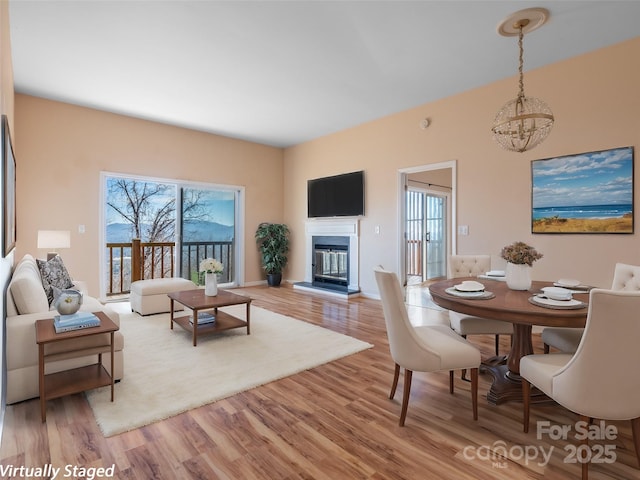 dining area with a notable chandelier, light hardwood / wood-style floors, and a healthy amount of sunlight