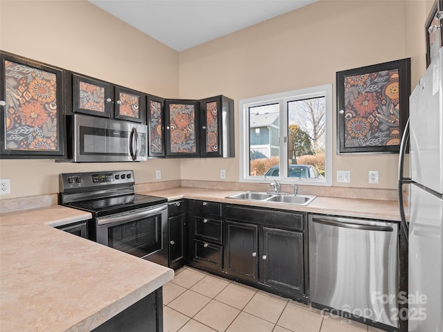 kitchen with sink, light tile patterned floors, and appliances with stainless steel finishes