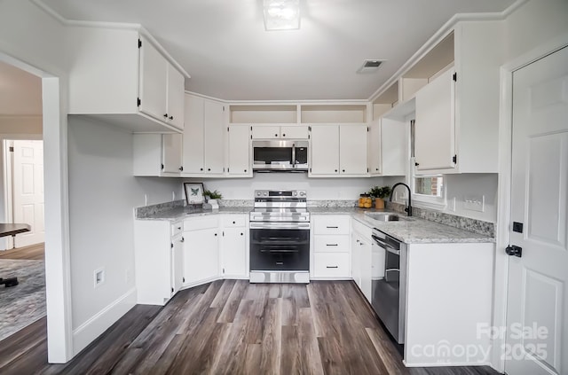 kitchen featuring sink, appliances with stainless steel finishes, white cabinetry, dark hardwood / wood-style floors, and light stone counters