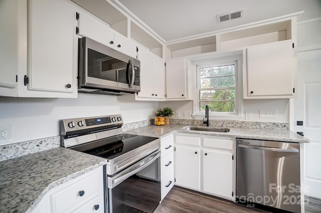 kitchen featuring light stone countertops, white cabinetry, appliances with stainless steel finishes, and sink