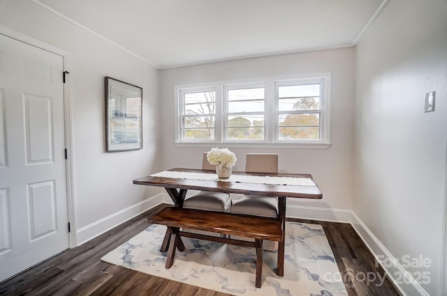 dining room with ornamental molding and dark hardwood / wood-style flooring