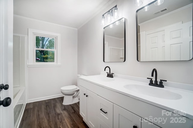 bathroom featuring ornamental molding, wood-type flooring, vanity, and toilet