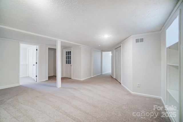 spare room with light carpet and a textured ceiling