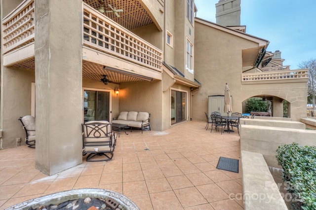 view of patio featuring a balcony, outdoor lounge area, and ceiling fan