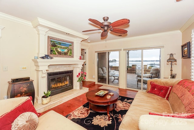 living room with hardwood / wood-style flooring, ornamental molding, ceiling fan, and a high end fireplace