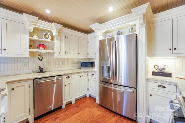 kitchen featuring light stone counters, stainless steel appliances, and white cabinets