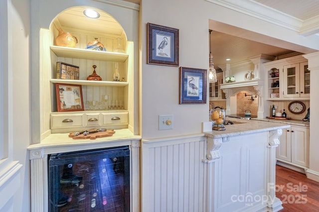 bar featuring crown molding, built in features, white cabinetry, decorative light fixtures, and beverage cooler