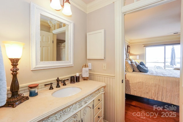 bathroom featuring vanity, hardwood / wood-style floors, and ornamental molding