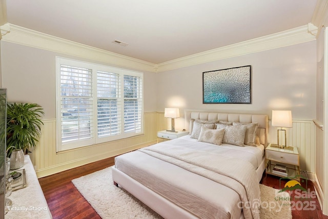 bedroom with ornamental molding and dark hardwood / wood-style floors