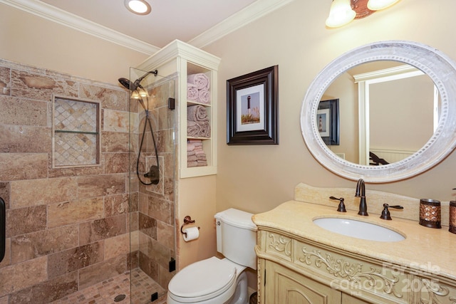 bathroom with vanity, crown molding, a shower with shower door, and toilet