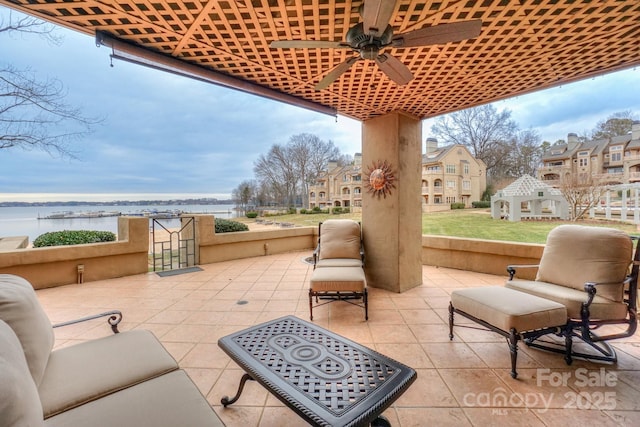 view of patio with ceiling fan and a water view