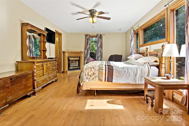 bedroom with light wood-type flooring and a fireplace
