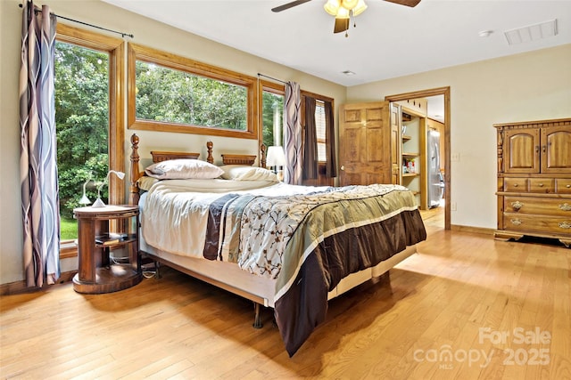 bedroom featuring light wood-style flooring, multiple windows, visible vents, and baseboards