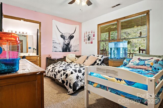 bedroom with ensuite bath, visible vents, ceiling fan, and carpet flooring