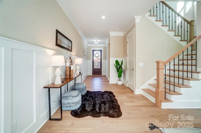 entryway featuring wood-type flooring and ornamental molding