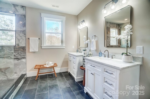 bathroom with tiled shower, vanity, tile patterned floors, and a wealth of natural light