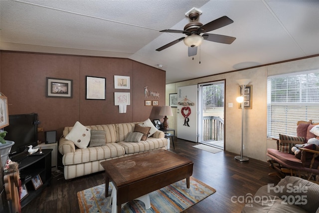 living room featuring dark wood-type flooring, ceiling fan, crown molding, and vaulted ceiling