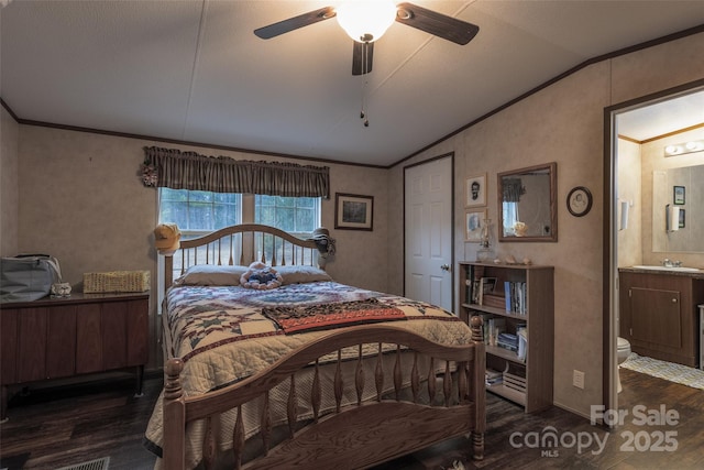 bedroom featuring connected bathroom, dark wood-type flooring, vaulted ceiling, and ornamental molding