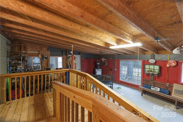 interior space with a healthy amount of sunlight, vaulted ceiling, and a wood stove