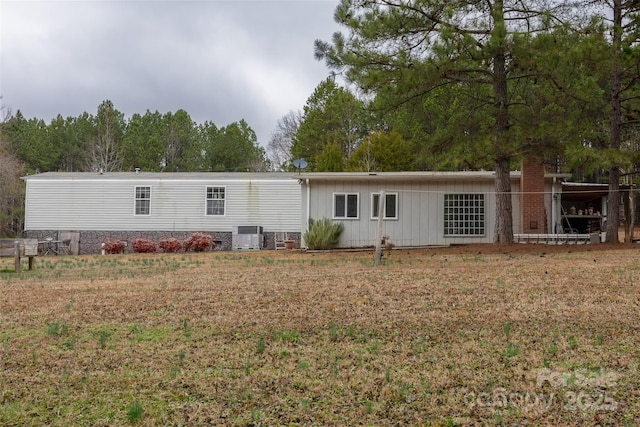 back of property with central air condition unit and a lawn