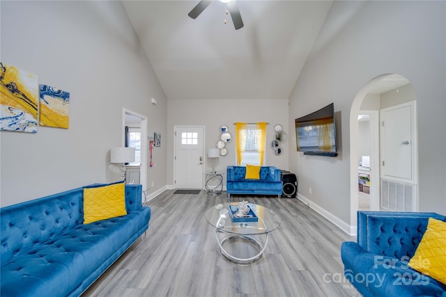 living room featuring light hardwood / wood-style flooring, high vaulted ceiling, and ceiling fan