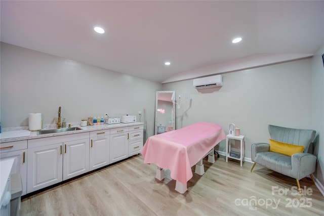 dining space with lofted ceiling, sink, a wall unit AC, and light wood-type flooring