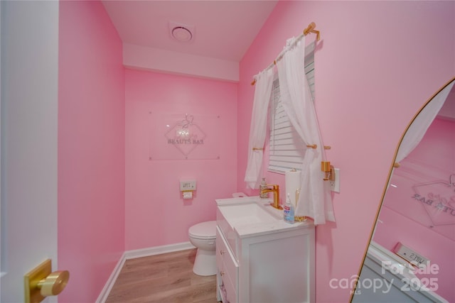 bathroom with hardwood / wood-style flooring, vanity, and toilet