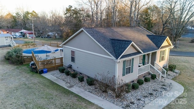 view of property exterior with a wooden deck and a lawn