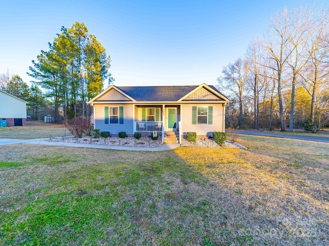 ranch-style home with a front yard and covered porch