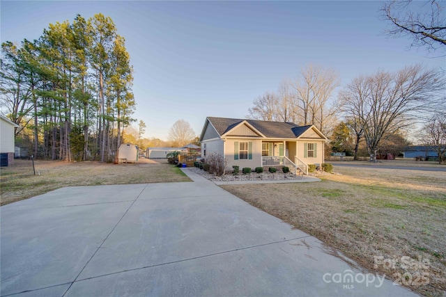 view of front of property with a porch, a front lawn, and a shed