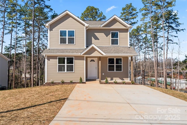 view of front of house featuring roof with shingles and a front lawn