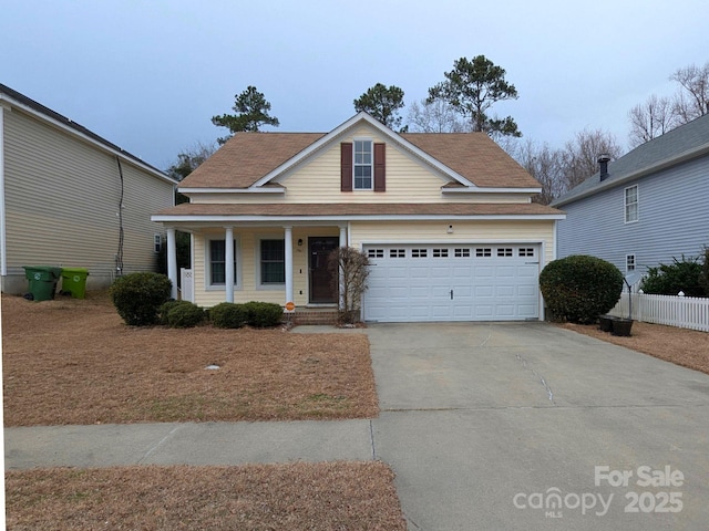 traditional home with a garage, concrete driveway, and covered porch