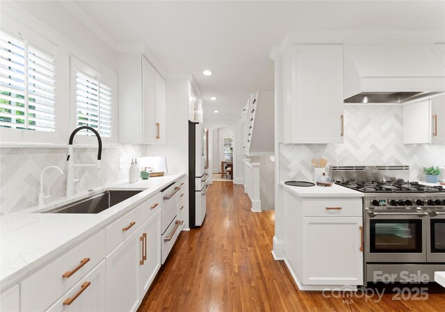 2809 Glendale Rd, Charlotte, NC 28209 - kitchen with double oven range, a sink, arched walkways, custom exhaust hood, and backsplash
