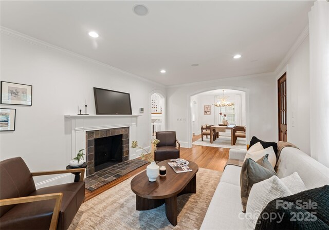 2809 Glendale Rd, Charlotte, NC 28209 - living room with arched walkways, light wood-type flooring, crown molding, recessed lighting, and a chandelier