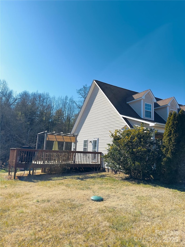 view of side of property with a yard and a deck