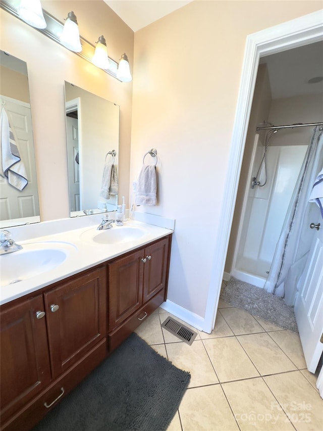 bathroom featuring tile patterned flooring, a shower, and vanity