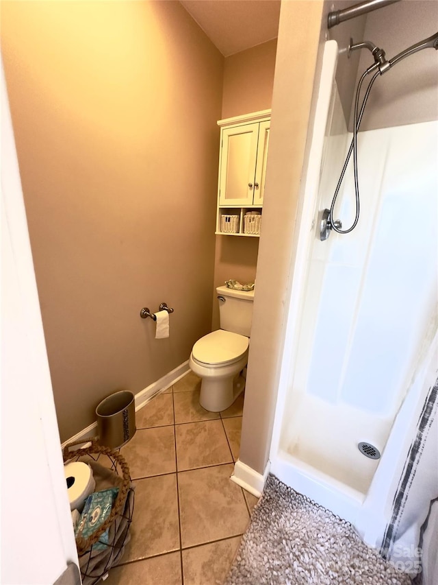 bathroom with tile patterned flooring, toilet, and walk in shower